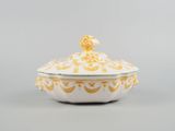 a white and gold covered dish with a bird on top