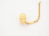 a close up of a gold necklace on a white surface