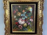 une peinture à l'huile représentant des fleurs, dans un cadre doré, accrochée à un mur bleu