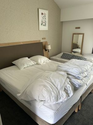 deux lits dans une chambre d'hôtel, recouverts de draps blancs