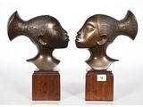 paire de sculptures en bronze représentant une tête de femme et une tête d'homme, posées sur des socles en bois
