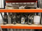 many bottles of motor oil on a shelf in a garage