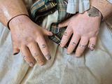 a close up of a person ' s hands with tattoos on them