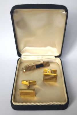 une boîte contenant une paire de boutons de manchette et un stylo