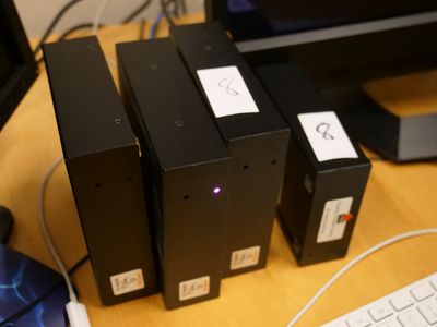 trois boîtes noires posées les unes à côté des autres sur un bureau