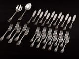 a lot of forks and spoons on a black table