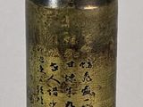 a small bottle with writing on it sitting on a table