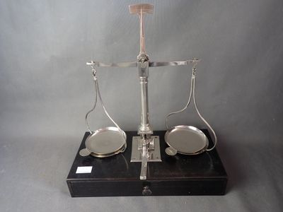 une balance posée sur une table, avec deux plateaux