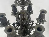 a metal candelab that has five candles on it