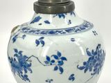a blue and white vase with a metal lid
