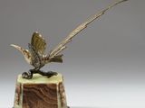 sculpture représentant un faisan perché sur un socle en bois de couleur verte
