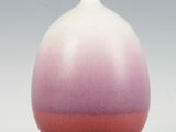 un vase blanc et rose posé sur une table blanche