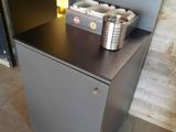 a small metal cabinet with two cups on top of it