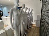de nombreux mannequins alignés en rang dans un magasin
