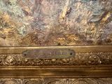 a sign on the ceiling of a room that has a painting on it