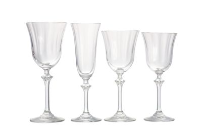 trois verres à vin vides posés l'un à côté de l'autre sur une surface blanche