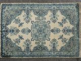 a blue and white rug sitting on top of a gray floor