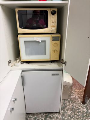 two microwaves stacked on top of each other in the kitchen