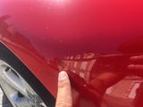 a hand that is pointing at a red car