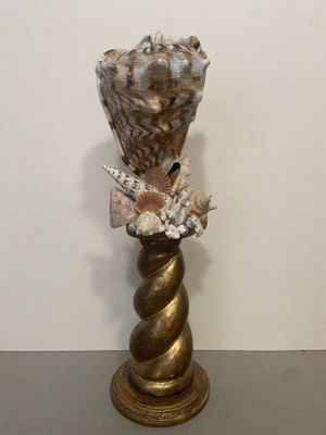 a vase that has shells in it on a table