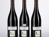 trois bouteilles de vin posées l'une à côté de l'autre sur une table