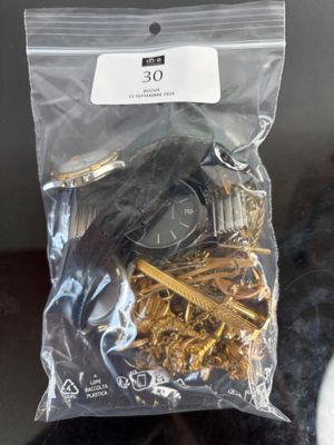 a bag of gold keys and a watch on a table