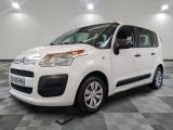 la petite camionnette blanche est garée sur un carrelage à carreaux