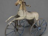 statue of a horse pulling a carriage on a gray background