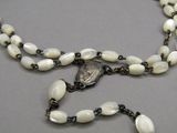 a long necklace with white beads and a silver clasp