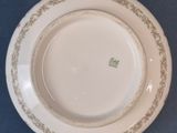 a white plate with gold trim on a blue table