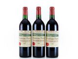 three bottles of red wine sitting next to each other on a white surface
