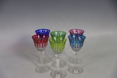 three wine glasses are lined up in a row on a white surface