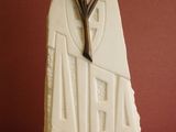 a white sculpture with a cross on it sitting on a table