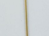 a gold pin with pearls on it on a white surface