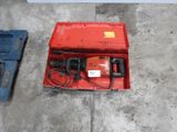 a red box with a drill in it sitting on the floor