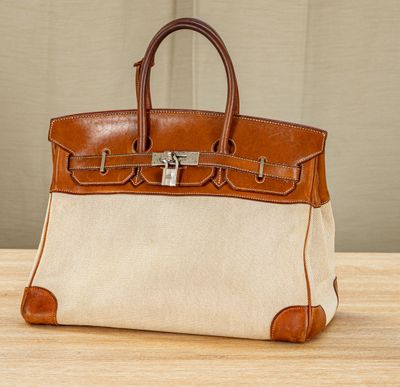 a brown and white purse sitting on top of a wooden table