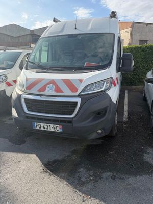 une camionnette blanche garée dans un parking à côté d'autres voitures