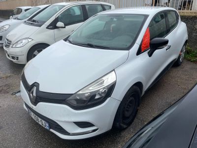une voiture blanche garée sur un parking, avec d'autres voitures en arrière-plan