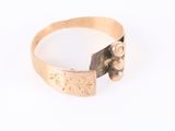 a close up of a gold ring on a white surface