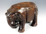 figurine d'éléphant en bois sculpté posée sur une surface blanche