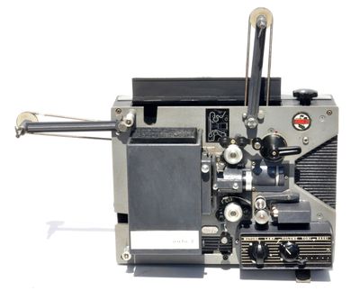 un vieux projecteur de cinéma posé sur une surface blanche