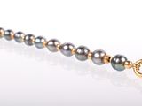 an image of a close up of a necklace on a white surface