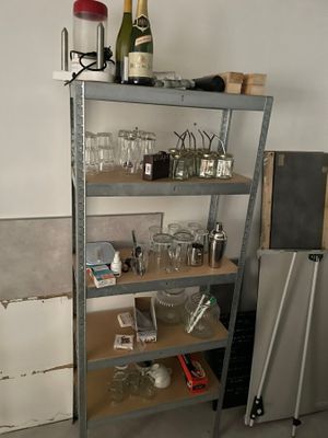 une étagère en métal sur laquelle sont posés des verres à vin et des bouteilles