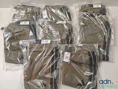 six pairs of men ' s pants wrapped in plastic on a white surface