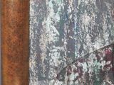 a picture of a cat sitting on a chair in front of a painting