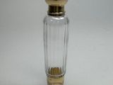 a small glass bottle with a gold top on a white surface