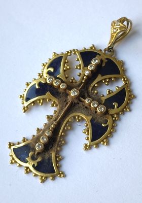 une image représentant un pendentif en forme de croix dorée et bleue sur un fond blanc