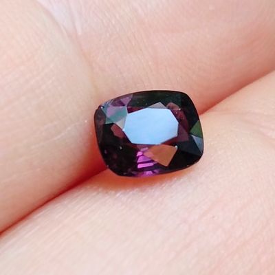 une image montrant un gros plan de la main d'une personne tenant une pierre précieuse violette