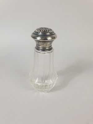 une petite salière et poivrière en verre avec un couvercle en argent
