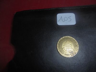 un portefeuille noir sur lequel repose une pièce d'or